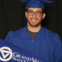 graduating student with grand valley state university flag
